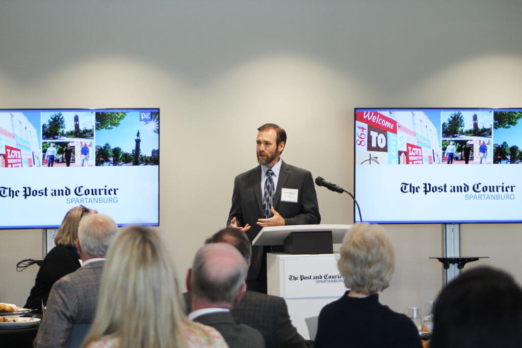a man making a presentation in front of a crowd
