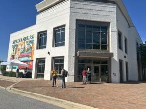 people standing in front of a building with a mural on one wall