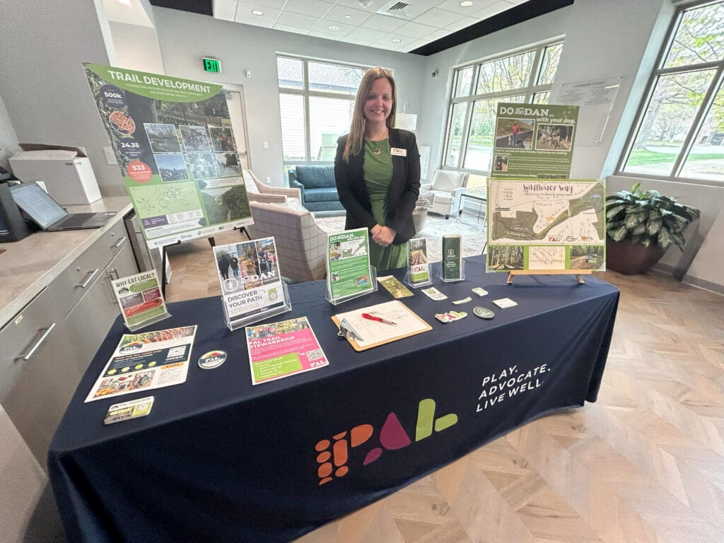 a woman stands at a table with materials displayed on it