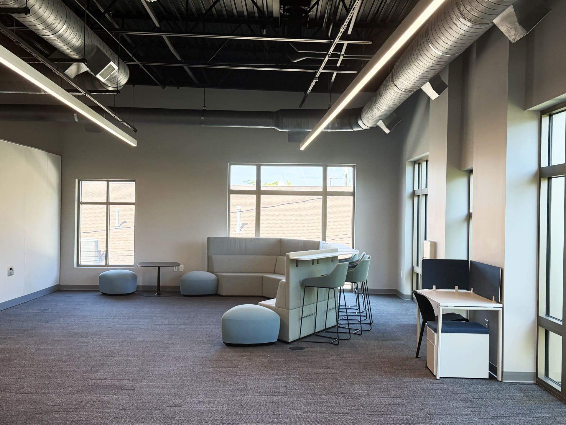 a room with a sectional sofa and desk